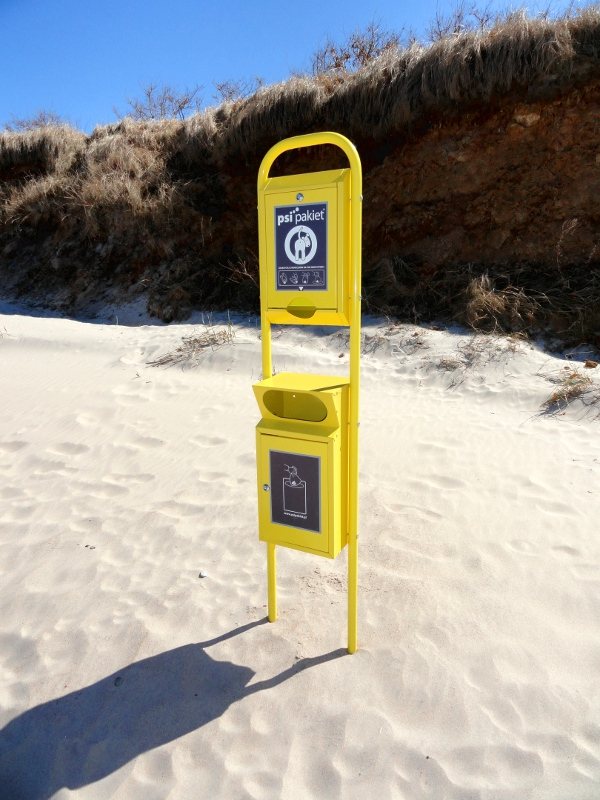 Sie sehen die Abfallbehälter mit Hundetüten an einem Hundestrand an der polnischen Ostsee