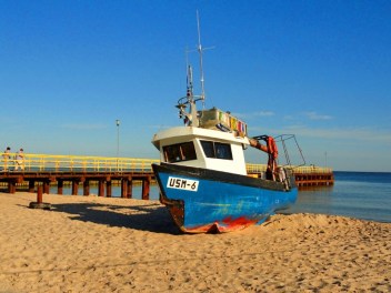 Sie sehen ein Arbeitsboot am Strand von Ustronie Morskie