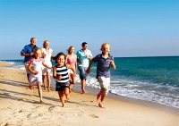 Sie sehen eine Familie in ihrem urlaub an der Ostsee in Polen - sie läuft am Strand entlang